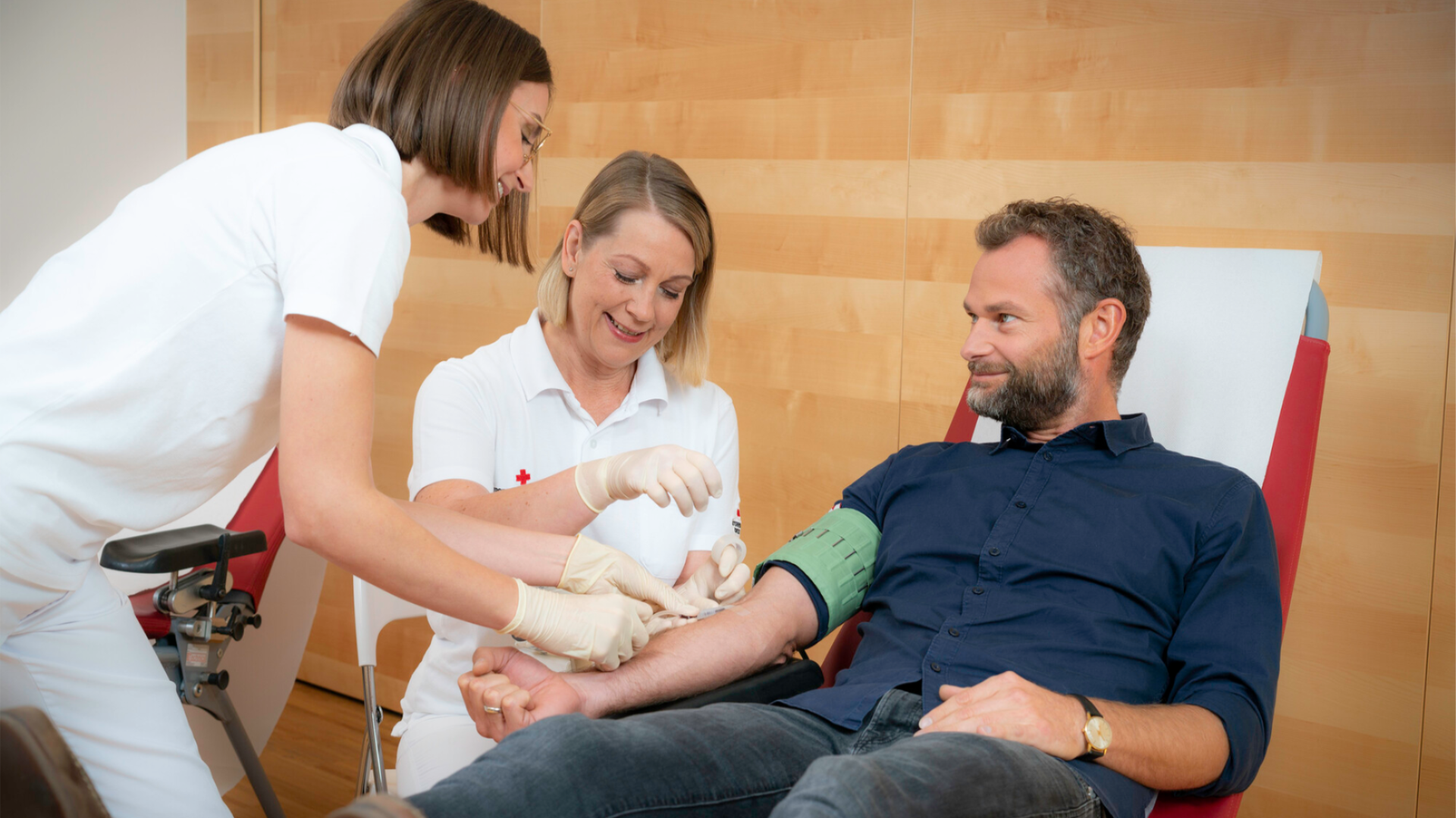 Zwei Diplomierte Gesundheits- und Krankenpflegerinnen nehmen einem Herrn gerade Blut ab. Foto Credit ÖRK Helmut Mitter